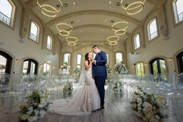 Elegant wedding couple surrounded by luxury wedding floral rentals in DFW, featuring timeless silk arrangements designed to photograph beautifully and elevate the ceremony space.